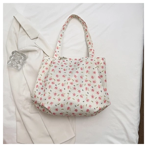 Detail of floral canvas tote bag with pink flower patterns on a creamy white fabric