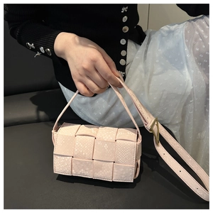 Detailansicht der rosa geflochtenen Tasche mit Schlangenhautmuster und Goldverschluss