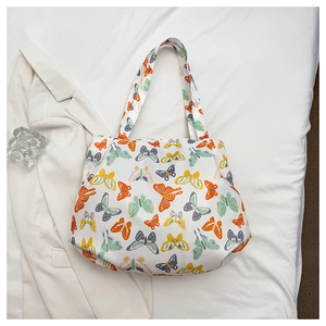 Detailed close-up of a white canvas tote bag with colorful butterfly prints on fabric