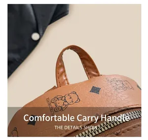 Detail eines karamellfarbenen Rucksacks aus genarbtem Leder mit Tragegriff und Bärenmuster