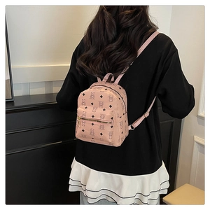 Detail eines rosa Mini-Rucksacks mit niedlichem Bären- und Rautenmuster am Modell