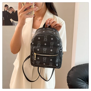 Detail eines schwarzen Mini-PU-Lederrucksacks mit weißem Bären-Print und Texturen