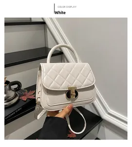 Detail of white quilted handbag featuring a signature gold T-shaped metallic lock closure