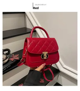 Close-up of red quilted handbag featuring a golden turn-lock and elegant top handle