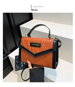 Close-up of woven texture handbag with brown finish and black contrast v-shaped flap detail