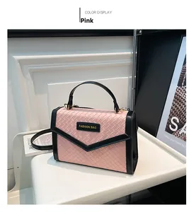 Detail of pink woven texture handbag with black contrast trim and adjustable strap