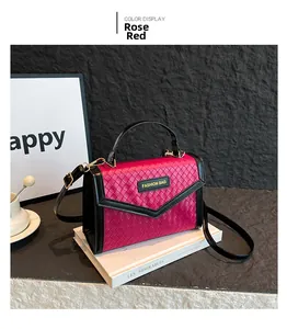 Detail of rose red woven small square handbag with black edge and Fashion Bag plaque