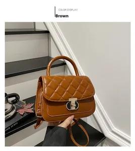 Detail of a brown quilted handbag with a gold metal twist lock and top handle
