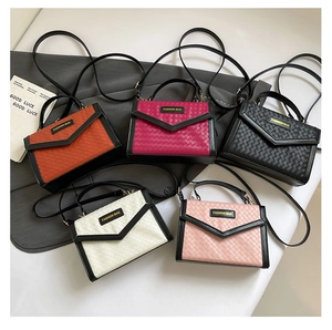 Detailed view of woven textures on small square handbags in five assorted fashion colors