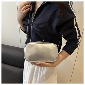 Detail view of a silver metallic chain bag with Fashion & Bags text on textured PU leather