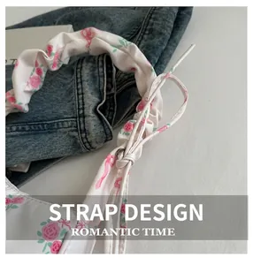Detailed close-up of ruffled drawstring shoulder strap with pink floral rose patterns