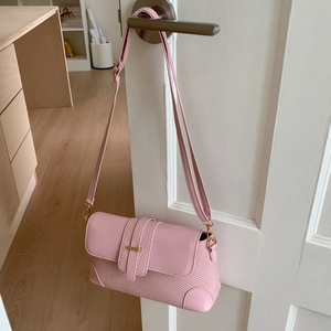 Détail du sac à bandoulière rose avec texture tissée et contraste en cuir lisse