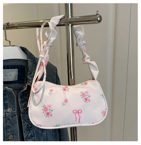 Détail du sac en toile florale avec motifs de roses roses, nœuds et bandoulière froncée