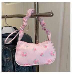 Détail d'un sac à main rose fleuri avec motifs roses et bandoulière froncée