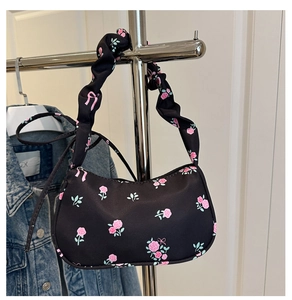 Vue détaillée du sac floral noir avec bandoulière froncée et motifs de roses roses