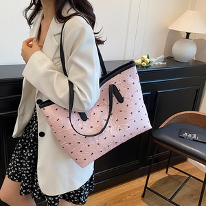 Sac cabas rose chic avec motifs nœuds noirs et tissu texturé porté par un mannequin