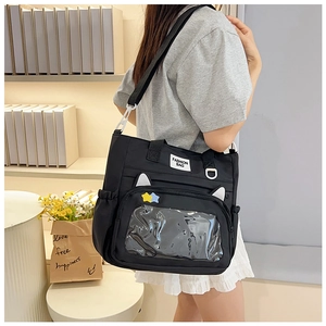 Détail du sac d'école noir avec fenêtre transparente et décoration d'oreilles de chat