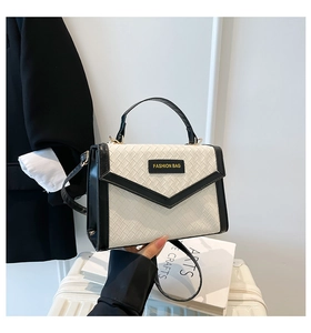 Close-up of contrast woven handbag with black leather trim and Fashion Bag logo detail