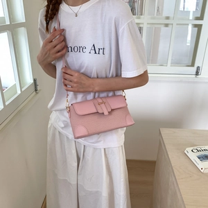 Elegante borsa a tracolla rosa con trama intrecciata e rifiniture in pelle su modella