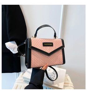 Detail of pink woven texture and black leather trim on a stylish square crossbody bag