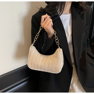 Nahaufnahme einer hellbeigen geflochtenen Hobo-Tasche mit luxuriöser goldener Kette