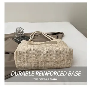 Detail of the durable woven base and white rope handle on a large beige summer tote bag