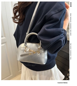 Close-up of a silver shell handbag with metallic finish and buckle strap detail