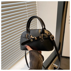 Dettaglio di una mini borsa a tracolla in pelle nera opaca con finiture dorate
