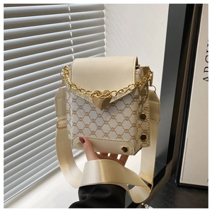 Détail du sac vintage avec motif triomphal, pendentif cœur doré et bandoulière large