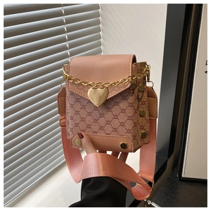 Détail du sac carré en jacquard rose avec fermoir cœur doré et bandoulière large