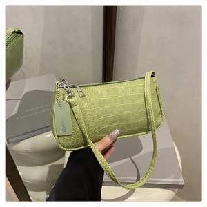Close-up of light green croc-embossed texture and silver zipper on the baguette bag