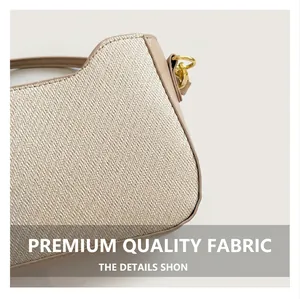 Close-up of beige woven fabric handbag with brown leather trim and gold metal ring