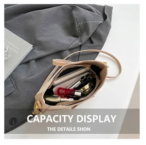Top view of beige leather handbag interior showing storage capacity for phone and makeup