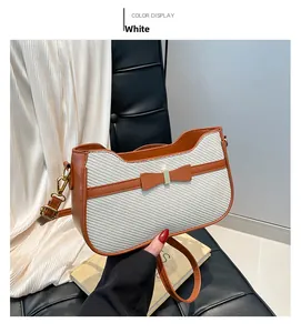Dettaglio di borsa intrecciata crema con finiture in pelle marrone e fiocco decorativo