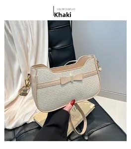 Dettaglio della borsa sottobraccio kaki con trama in paglia diagonale e fiocco in pelle