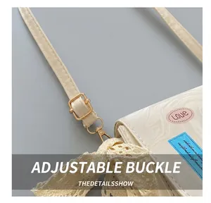 Detail showing adjustable golden buckle and ivory leather strap with lace scarf detail