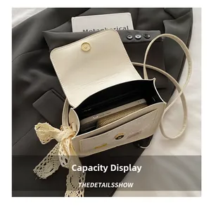 Internal view of cream shoulder bag showing capacity for phone and wallet with lace detail
