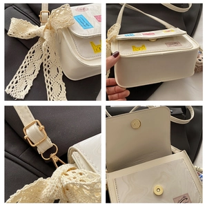 Close-up of cream shoulder bag with lace bow, marble flap and colorful patches