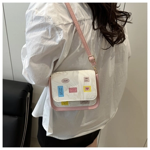 Detail of pink and beige crossbody bag with marble texture and colorful cat embroidery