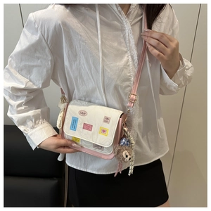 Detail of pink and white paneled tote with cute patches and a plush bear pendant