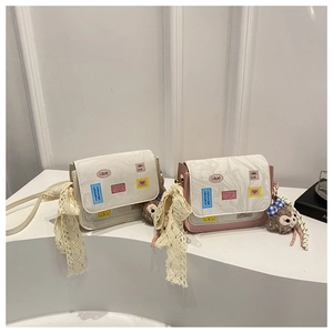 Detail of mini crossbody bags with marble texture flap, lace bow, and plush charm