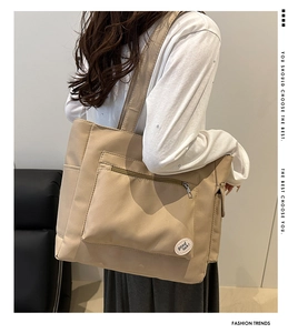 Detail of khaki canvas tote with 'good luck!' embroidery and practical side pocket