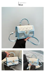 Detail of embossed retro crossbody bag with golden flower clasp and twisted handle design