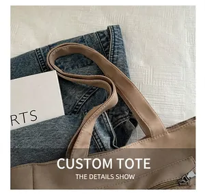 Detailed view of brown nylon tote bag with reinforced handles and sturdy exterior zip pocket