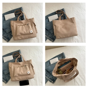 Detail of canvas tote bag showing spacious interior with books and front zipper pocket
