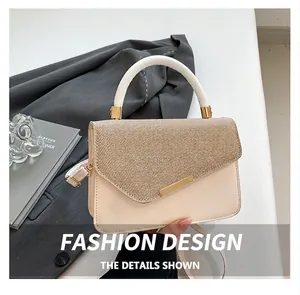Detail of color-block tote bag with woven texture and gold metal clasp decoration