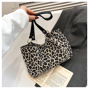 Detailopname van de luipaardprint canvas shopper met zwarte lederen handvatten en ringen