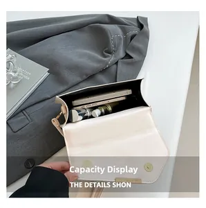 Interior view of small cream crossbody bag showing capacity for phone and lipstick