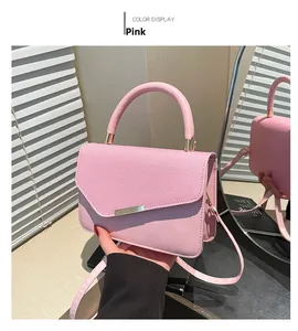 Detail of pink small square bag featuring textured fabric and gold metal clasp