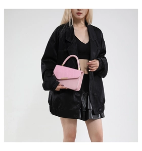 Close-up of pink shoulder bag featuring a stylish textured flap and gold metal clasp